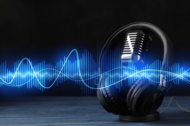 Image of Headphones, microphone and sound waves against black background