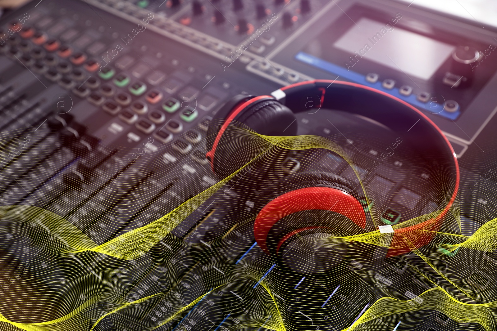 Image of Headphones on professional mixing console and sound waves