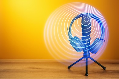 Image of Headphones, microphone and sound waves against orange background