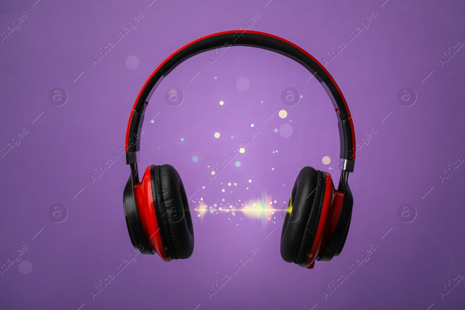 Image of Headphones and sound waves against purple background