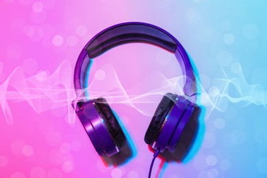 Image of Headphones and sound waves on pink blue background
