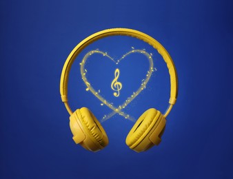 Image of Headphones and heart shape of music notes against blue background