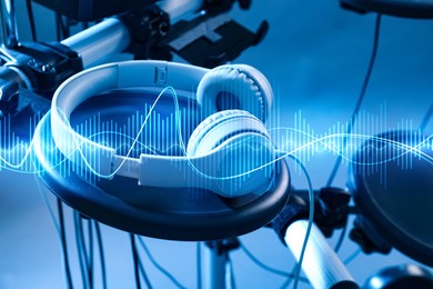 Image of Headphones, electronic drum kit and sound waves, toned in blue