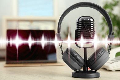 Image of Headphones and microphone on table and sound waves