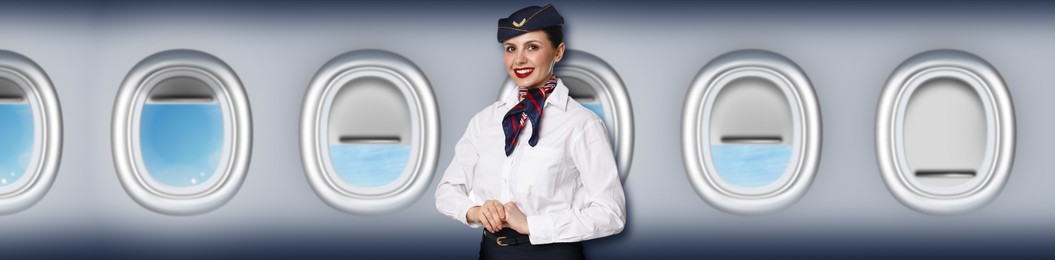 Image of Air hostess smiling near windows in plane
