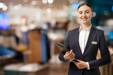 Image of Young hostess with clipboard in boutique. Space for text