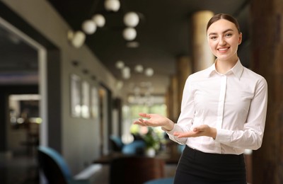 Image of Young hostess welcoming to restaurant. Space for text