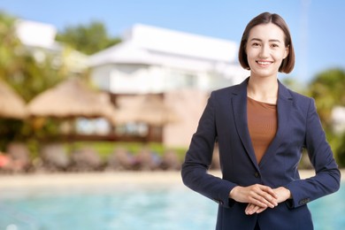 Image of Young hostess smiling near resort outdoors. Space for text