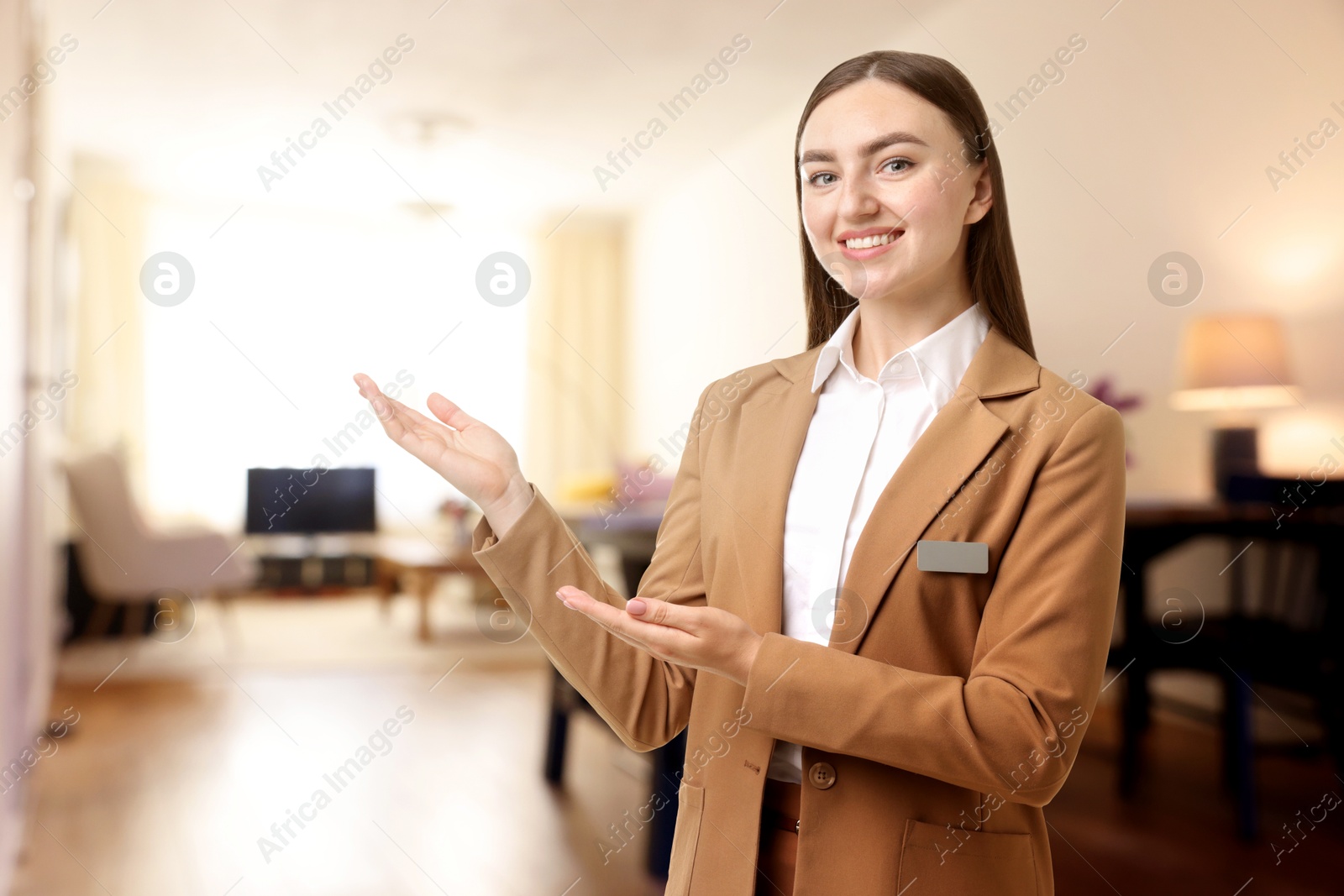 Young hostess welcoming to hotel room. Space for text Image of Young hostess welcoming to hotel room. Space for text