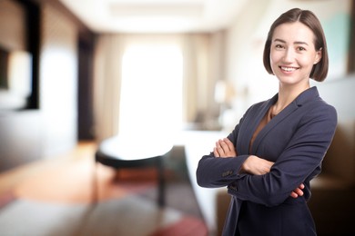 Image of Young hostess smiling in hotel room. Space for text