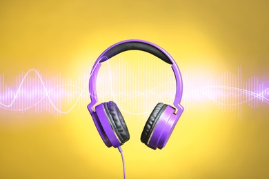 Image of Headphones and sound waves against yellow gradient background