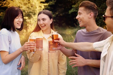 Photo of Group of happy friends clinking glasses of beer outdoors