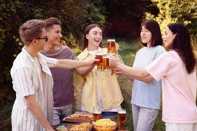 Photo of Group of happy friends clinking glasses of beer outdoors