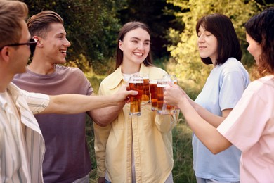 Photo of Group of happy friends clinking glasses of beer outdoors