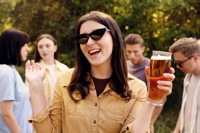 Photo of Group of happy friends having fun and drinking beer outdoors, selective focus