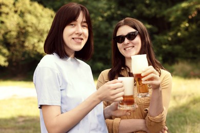 Photo of Young women with glasses of beer outdoors