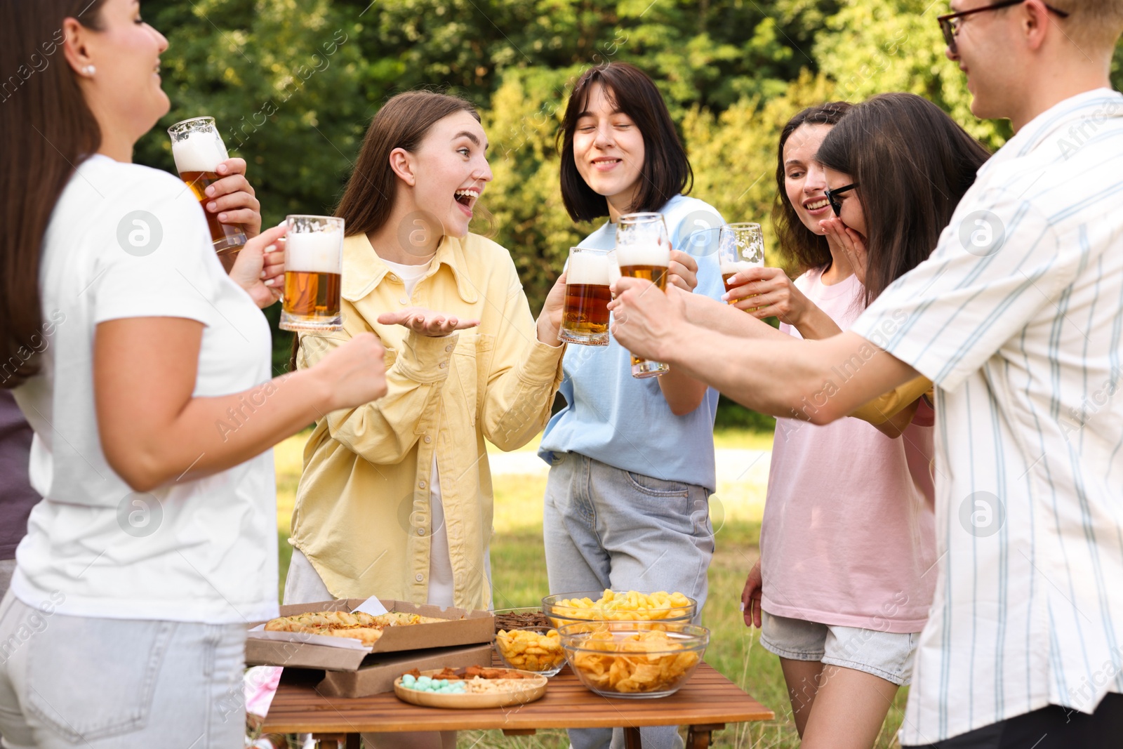 Group of happy friends having fun and drinking beer outdoors Photo of Group of happy friends having fun and drinking beer outdoors
