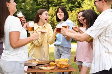 Photo of Group of happy friends having fun and drinking beer outdoors
