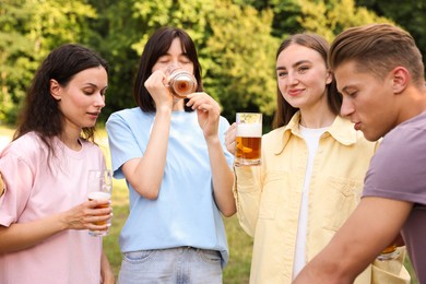 Photo of Group of happy friends having fun and drinking beer outdoors