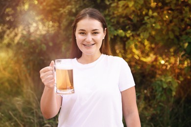 Photo of Young woman with glass of beer outdoors