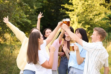 Photo of Group of happy friends clinking glasses of beer outdoors