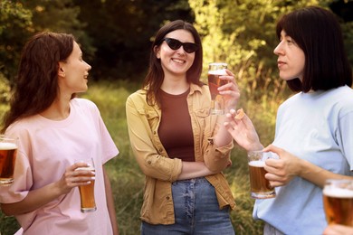 Photo of Group of happy friends having fun and drinking beer outdoors