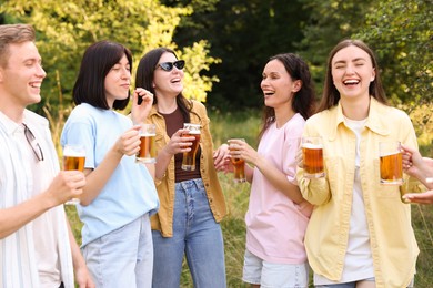 Photo of Group of happy friends having fun and drinking beer outdoors