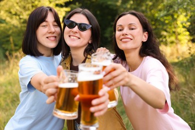 Photo of Group of happy friends having fun and drinking beer outdoors