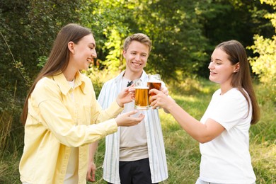 Photo of Group of happy friends clinking glasses of beer outdoors