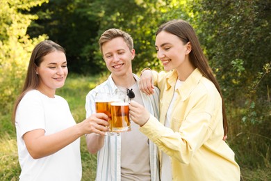 Photo of Group of happy friends clinking glasses of beer outdoors