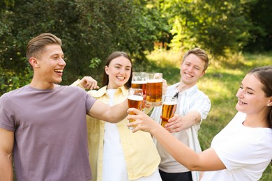 Photo of Group of happy friends clinking glasses of beer outdoors