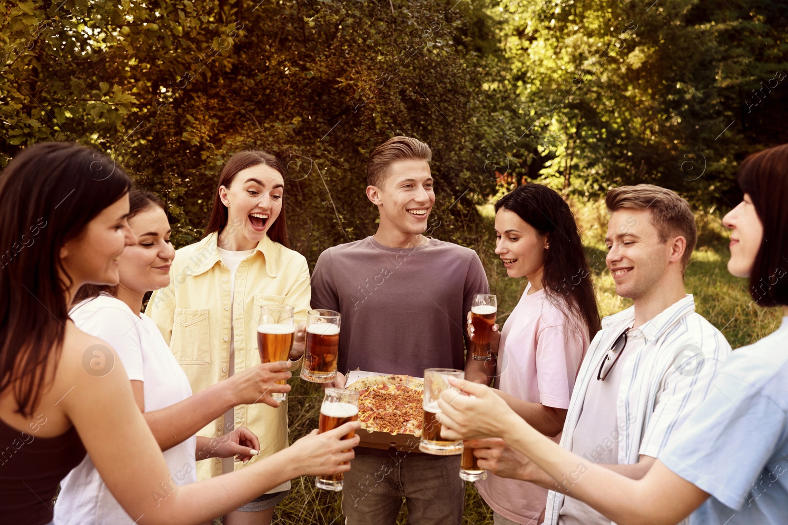 Group of happy friends with pizza having fun and drinking beer outdoors Photo of Group of happy friends with pizza having fun and drinking beer outdoors