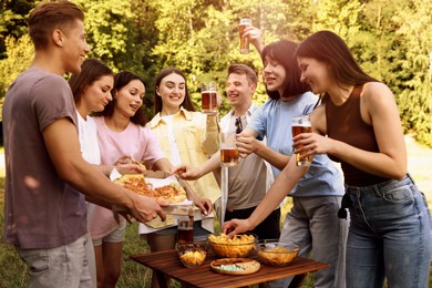 Photo of Group of happy friends having fun and drinking beer outdoors