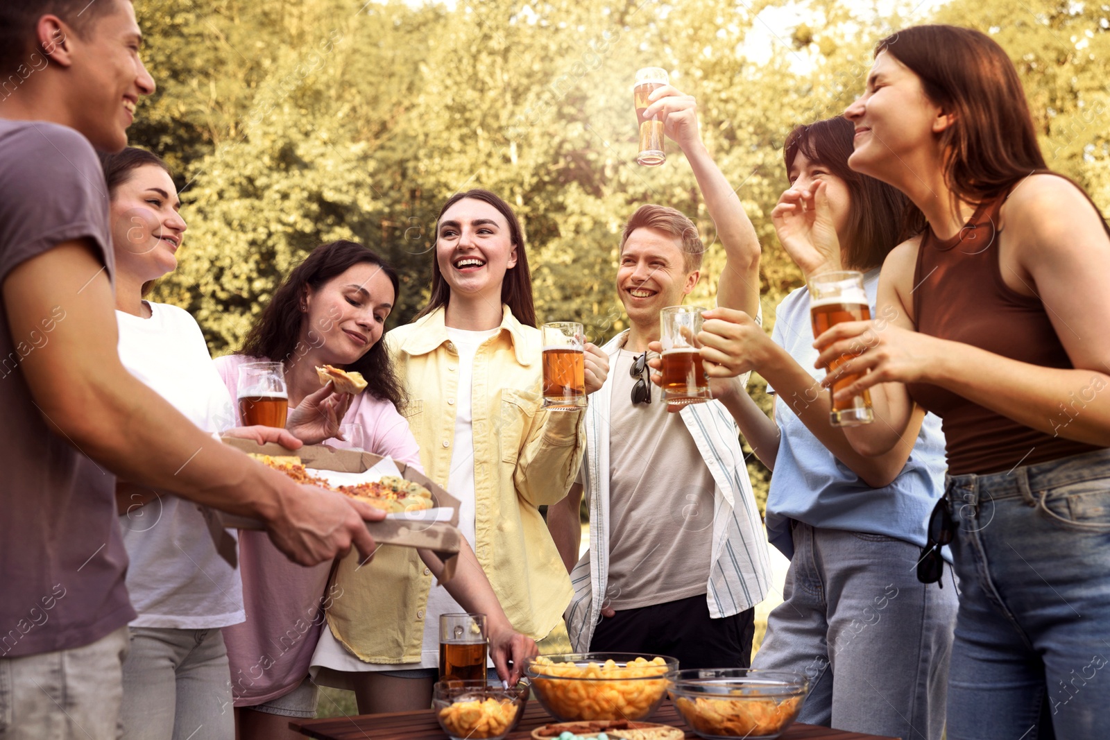 Photo of Group of happy friends having fun and drinking beer outdoors