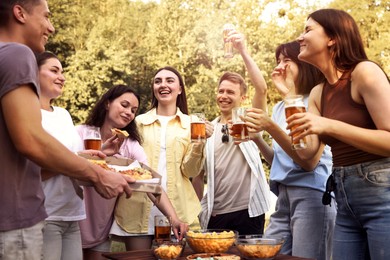 Photo of Group of happy friends having fun and drinking beer outdoors