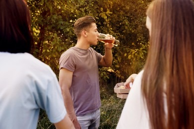 Photo of Group of happy friends having fun and drinking beer outdoors
