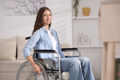 Photo of Smiling teenage girl in wheelchair at home
