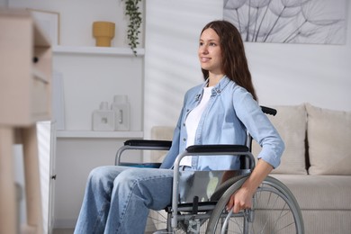 Photo of Smiling teenage girl in wheelchair at home