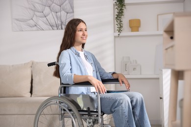 Photo of Smiling teenage girl in wheelchair at home