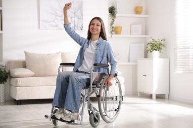 Photo of Smiling teenage girl in wheelchair at home