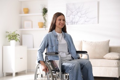 Photo of Smiling teenage girl in wheelchair at home