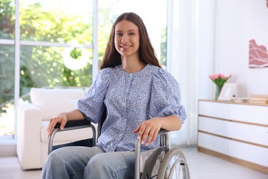 Photo of Smiling teenage girl in wheelchair at home