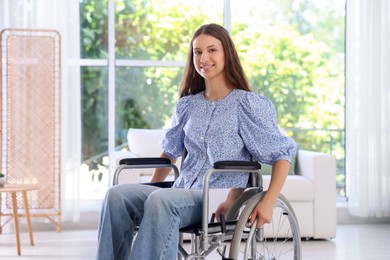 Photo of Smiling teenage girl in wheelchair at home