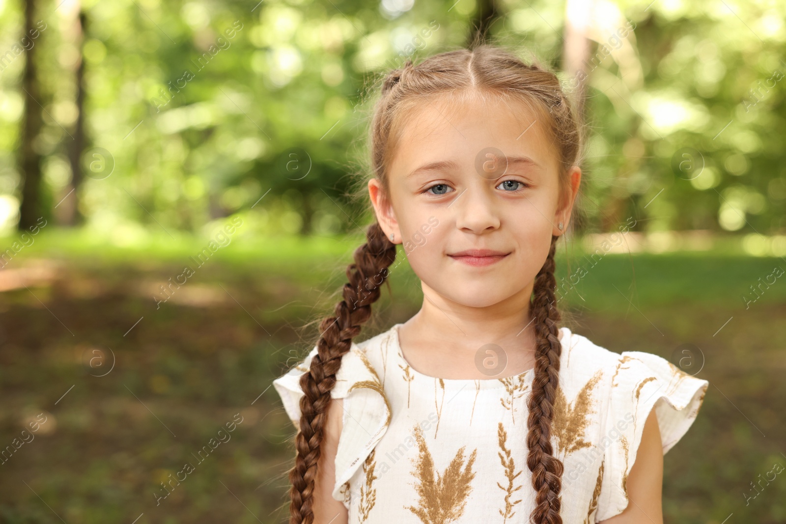 Photo of Portrait of cute little girl in park, space for text