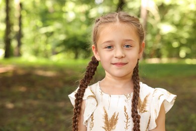 Photo of Portrait of cute little girl in park, space for text