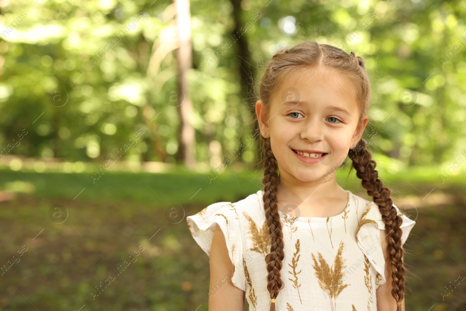 Photo of Portrait of cute little girl in park, space for text
