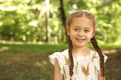 Photo of Portrait of cute little girl in park, space for text