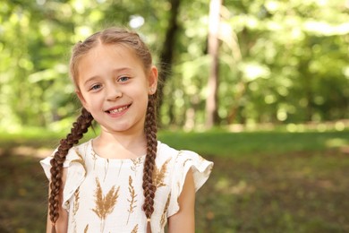 Photo of Portrait of cute little girl in park, space for text