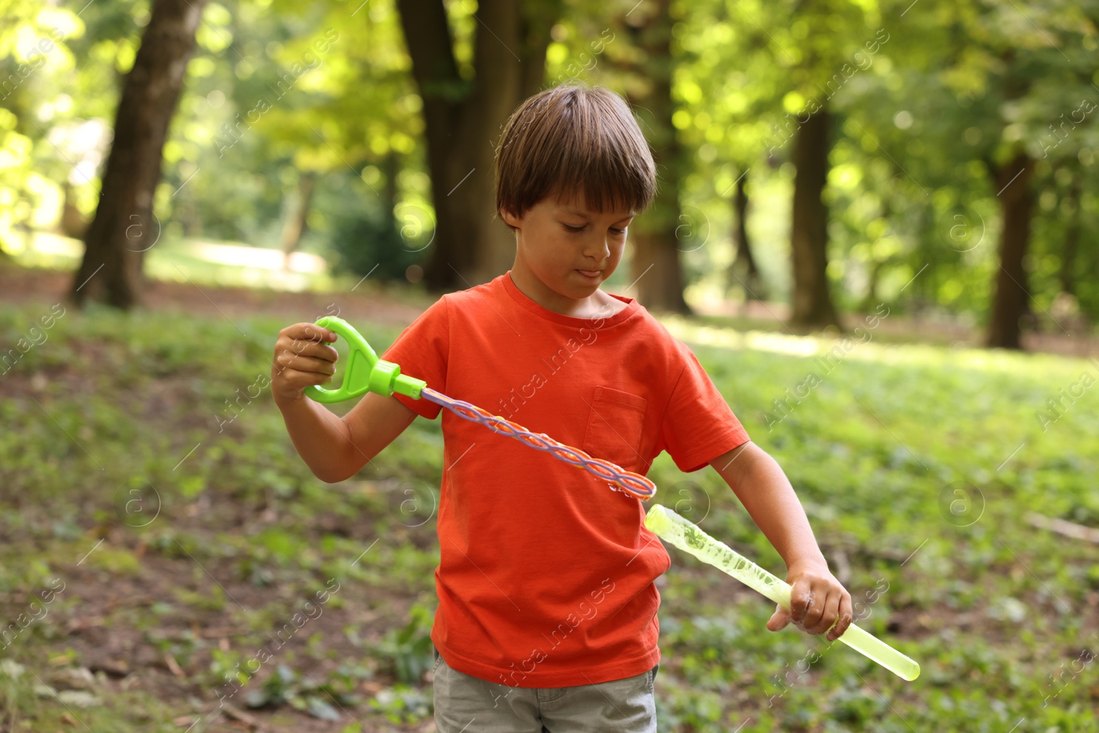 Photo of Cute little boy with bubble wand in park