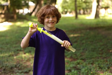 Photo of Cute little boy with bubble wand in park